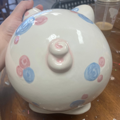 Ceramic piggy bank with colorful polka dots on a wooden surface